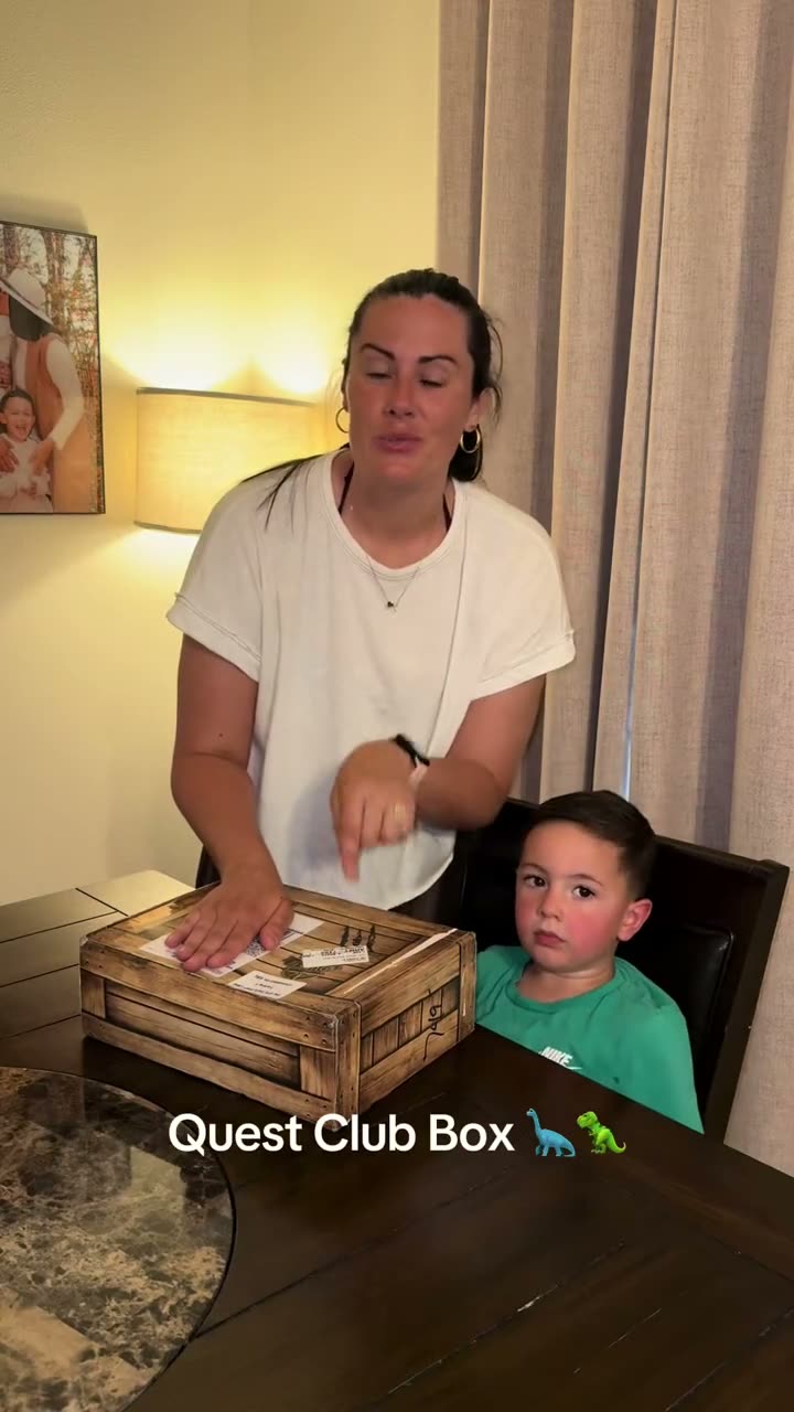 Mom and son opening their Quest Club box at the table